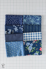 Nine patch of blue fabric squares on a grid background