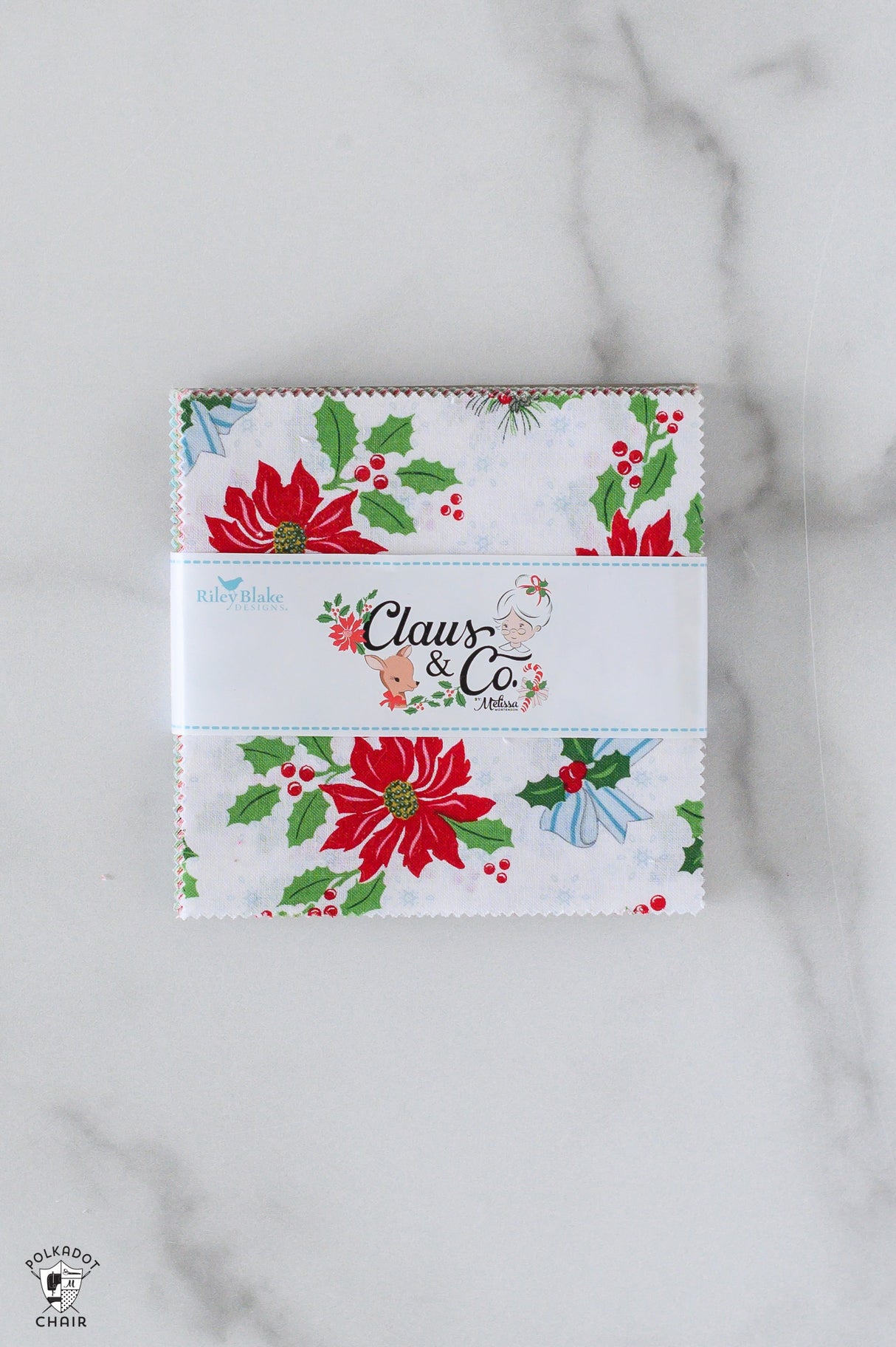 Christmas-themed fabric panel with 'Claus & Co' branding on a marble surface