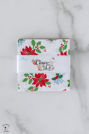 Christmas-themed fabric panel with 'Claus & Co' branding on a marble surface