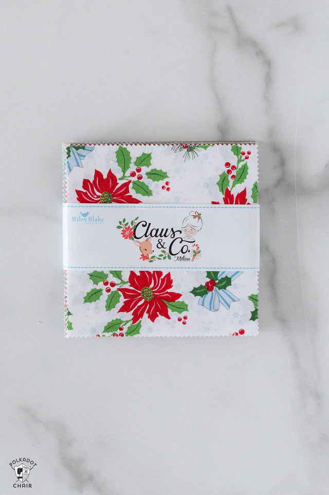 Christmas-themed fabric panel with 'Claus & Co' branding on a marble surface