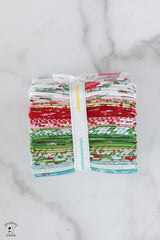 Stack of colorful fabric bundles tied with a white ribbon on a marble surface