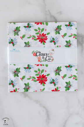 Holiday-themed product packaging with 'Claus & Co' branding on a marble surface.