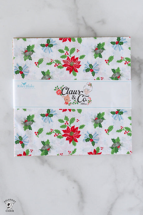 Holiday-themed product packaging with 'Claus & Co' branding on a marble surface.