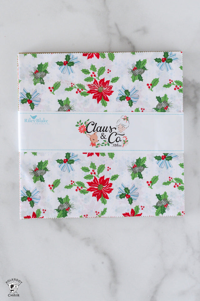 Holiday-themed product packaging with 'Claus & Co' branding on a marble surface.