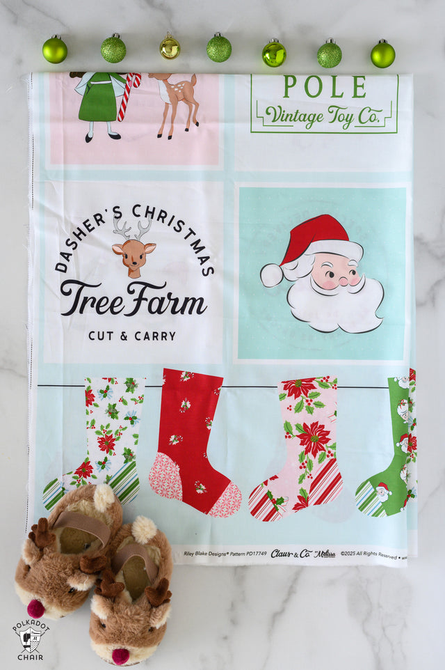 Christmas-themed fabric panel with Santa Claus, reindeer, and stockings on a white background.