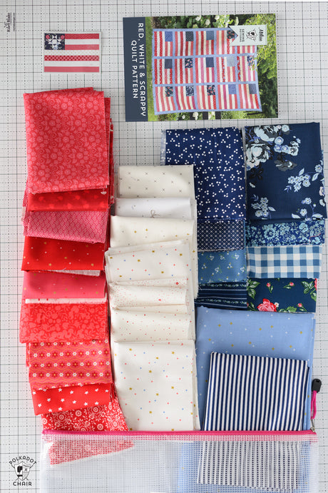 Collection of red, white, and blue fabric swatches on a grid background with a quilt pattern poster.