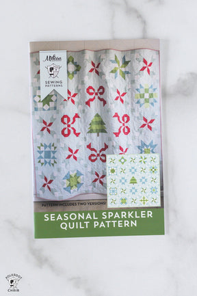 Seasonal Sparkler quilt pattern packaging on a marble surface