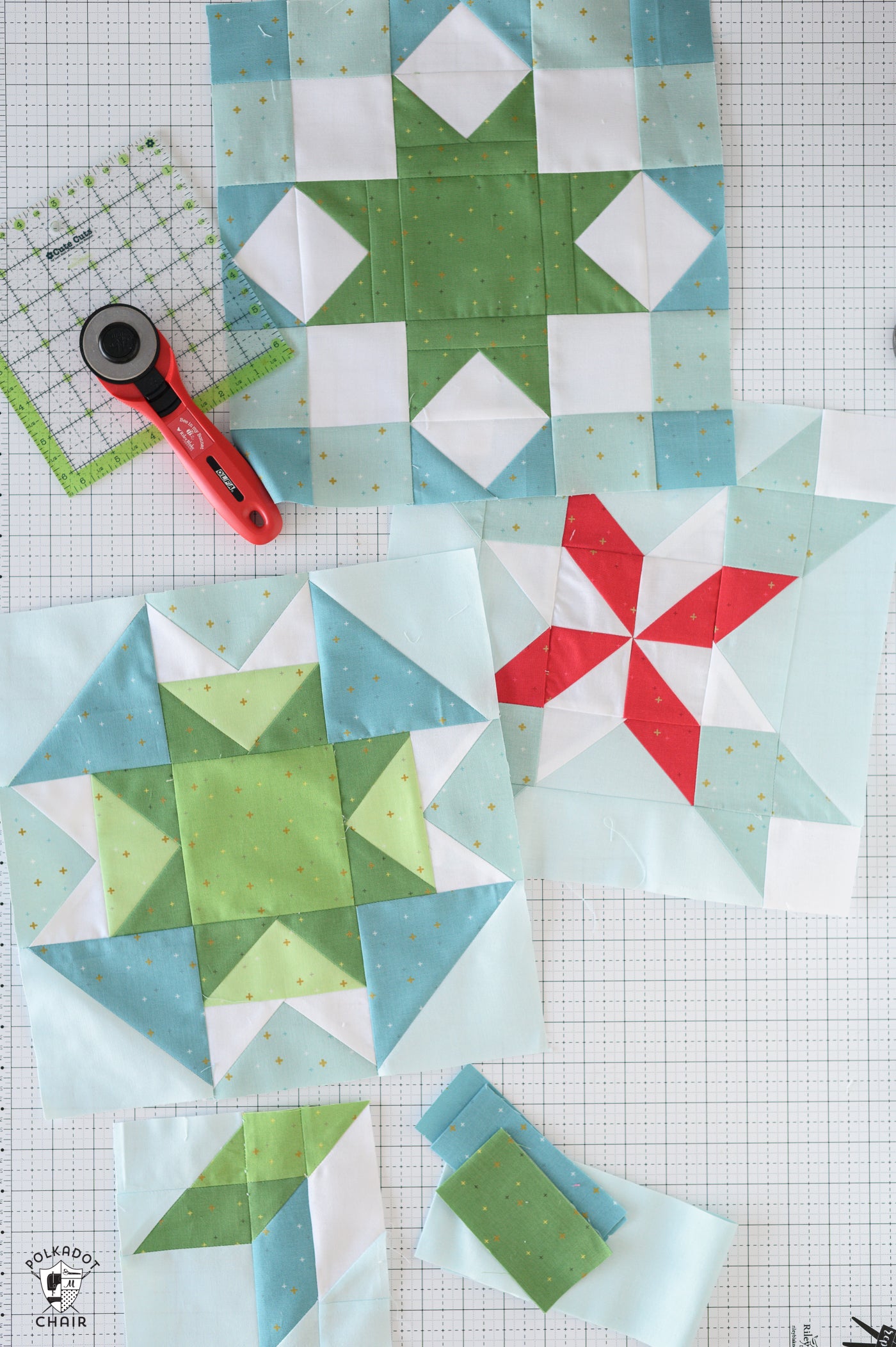 Quilt blocks with geometric patterns on a grid background, featuring a rotary cutter.